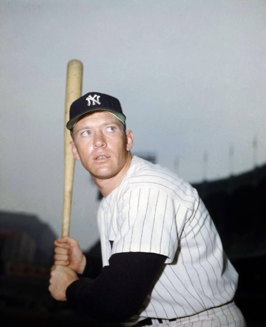 Mickey Mantle in a Yankees cap and pinstripes, posing with a bat, 1957.